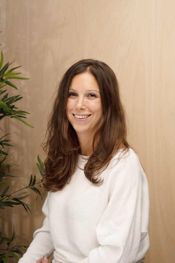 Vrouw met lang bruin haar in een witte trui