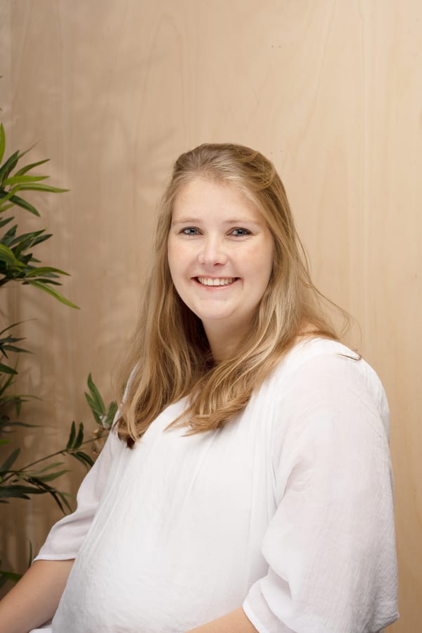 Vrouw met blond haar in een witte blouse