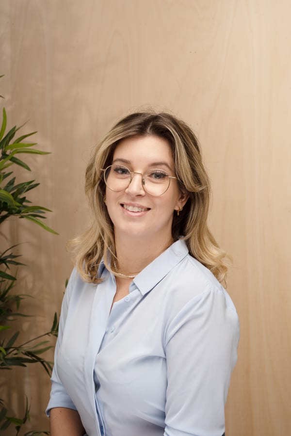 Vrouw met bril in een lichtblauwe blouse
