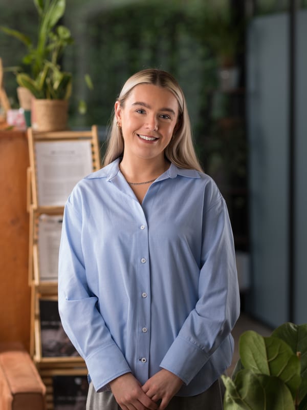 Vrouw met lang blond haar in een lichtblauwe blouse