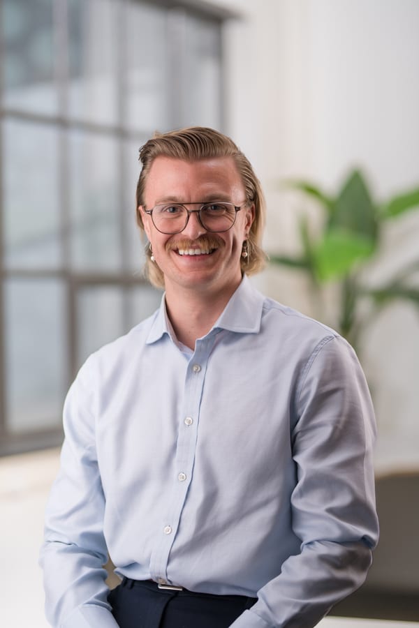 Man met bril en halflang haar in een lichtblauw overhemd